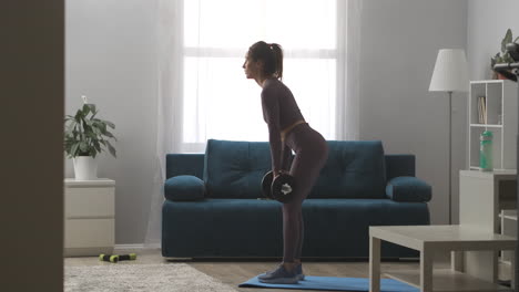 home-training-with-dumbbells-young-sexy-woman-is-holding-weights-in-hands-and-leaning-forward-in-living-room-healthy-lifestyle-and-wellness-power-training
